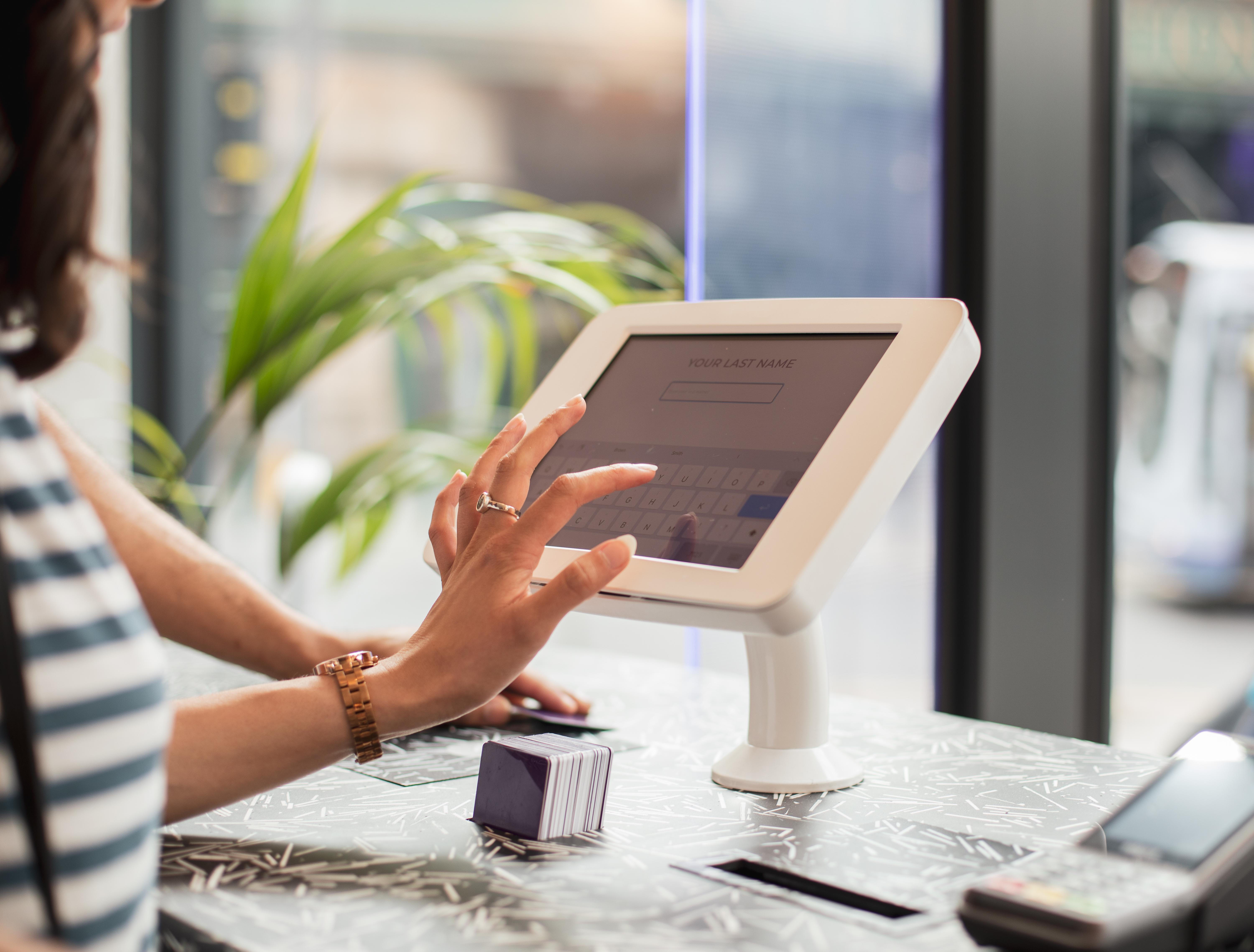Yotel Glasgow Dış mekan fotoğraf A woman using a tablet to enter her name at a check-in desk