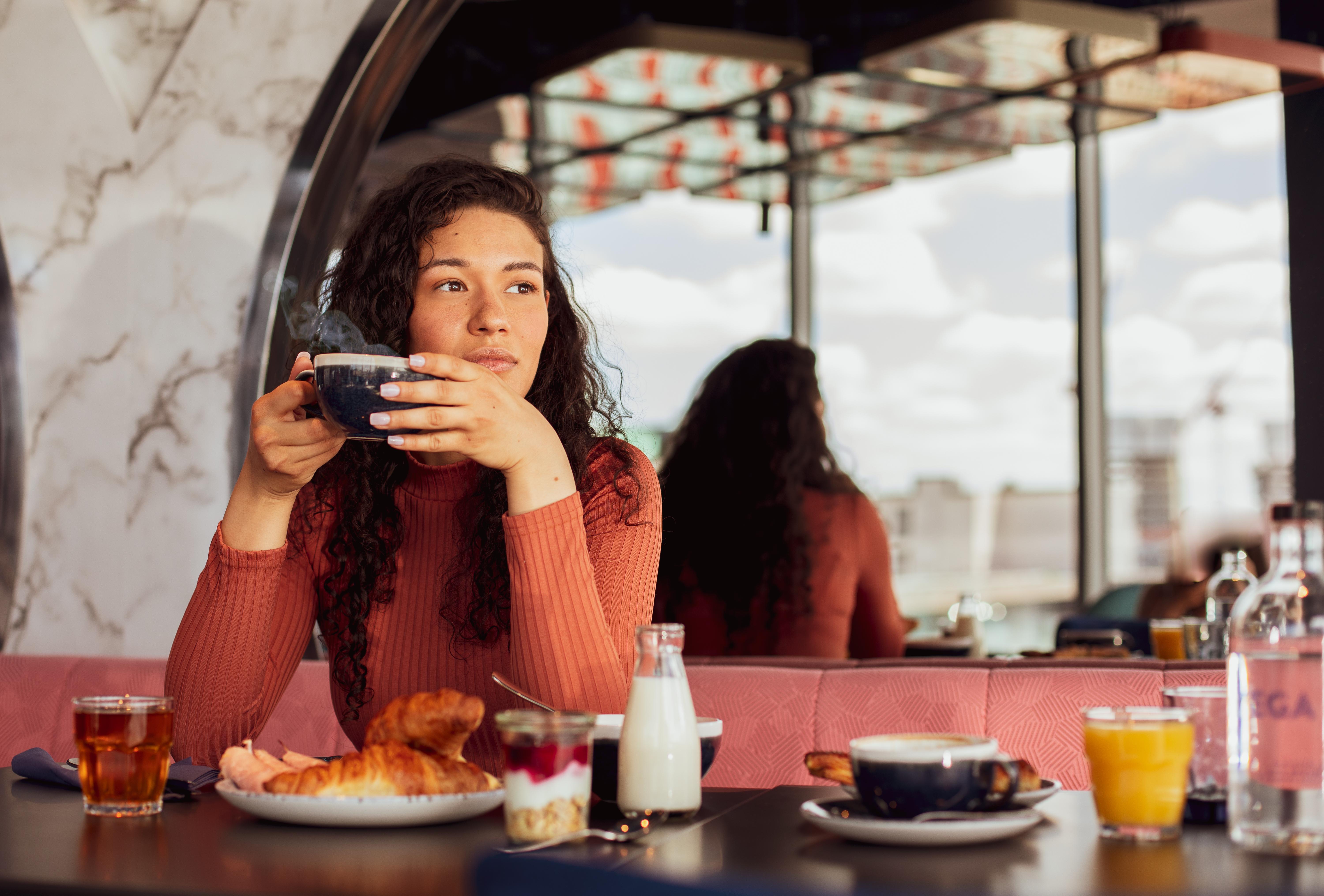 Yotel Glasgow Dış mekan fotoğraf A woman having breakfast at a cafe.